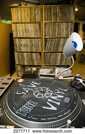 Stock Image - Turntable and a collection of vinyl records and LPs in a DJ's basement; Boston, Massachusetts, United States of America. Fotosearch