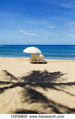 Two beach chairs with umbrella on Hulupo'e Beach, Manele Bay; Lanai, Hawaii, United States of America View Large Photo Image Stock Photo - Two beach chairs with umbrella on Hulupo'e Beach, Manele Bay; Lanai, Hawaii, United States of America. Fotosearch
