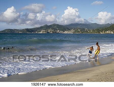 Stock Photo - Two Boys Playing In Surf On Beach. Fotosearch