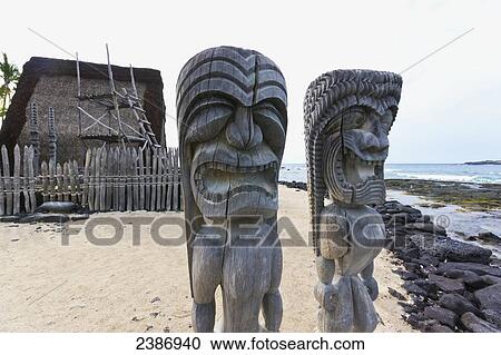 Stock Image - Two carved statues on the beach of City of Refuge National Historical Park; Island of Hawaii, Hawaii, United States of America. Fotosearch