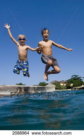 Two Children Jumping Off Platform Into The Sea; Discovery Bay Jamaica View Large Photo Image Picture - Two Children Jumping Off Platform Into The Sea; Discovery Bay Jamaica. Fotosearch