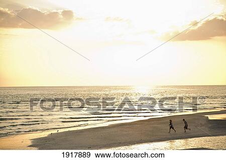 Two Children Running On Beach At Sunset View Large Photo Image Stock Photo - Two Children Running On Beach At Sunset. Fotosearch