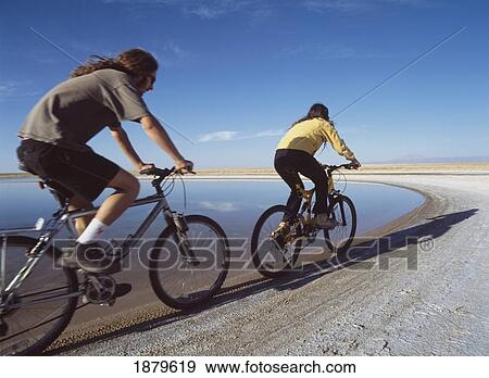 Stock Photo - Two Cyclists Going Around Laguna De Cejar. Fotosearch