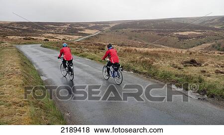Stock Photo - Two Cyclists In Red On The Moors Of Exmoor, Lynmouth, United Kingdom. Fotosearch