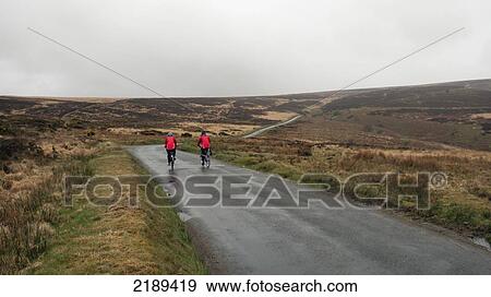 Stock Photo - Two Cyclists In Red On The Moors Of Exmoor, Lynmouth, United Kingdom. Fotosearch