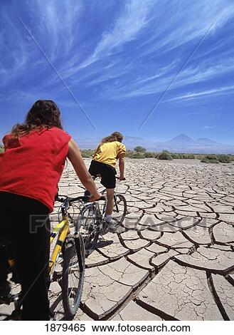 Two Cyclists Travelling Over Cracked Mud In The Atacama Desert View Large Photo Image Stock Photography - Two Cyclists Travelling Over Cracked Mud In The Atacama Desert. Fotosearch