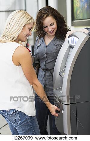 Two friends at an ATM at the shopping mall; St. Albert, Alberta, Canada View Large Photo Image Stock Photo - Two friends at an ATM at the shopping mall; St. Albert, Alberta, Canada. Fotosearch