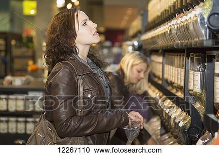 Two girlfriends shopping for groceries in an organic market; St. Albert, Alberta, Canada View Large Photo Image Stock Image - Two girlfriends shopping for groceries in an organic market; St. Albert, Alberta, Canada. Fotosearch