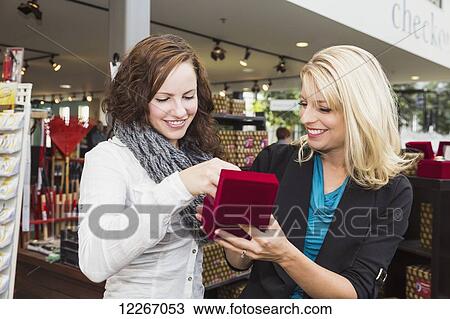 Stock Image - Two girlfriends shopping in a mall together; St. Albert, Alberta, Canada. Fotosearch