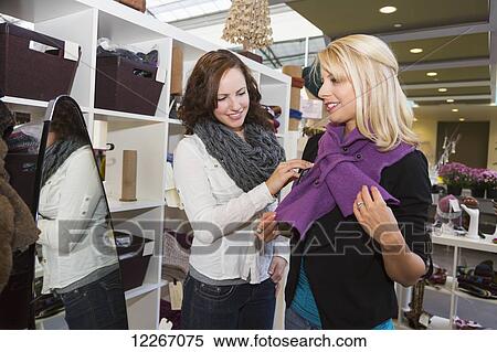 Stock Photography - Two girlfriends shopping in a mall together and trying on clothes; St. Alberta, Alberta, Canada. Fotosearch