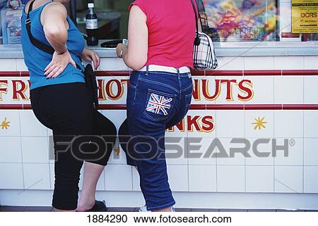 Stock Image - Two Girls At Food Stall. Fotosearch