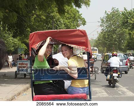 Two Girls Riding A Rickshaw Down A Busy Street; Delhi Uttar Pradesh India View Large Photo Image Picture - Two Girls Riding A Rickshaw Down A Busy Street; Delhi Uttar Pradesh India. Fotosearch
