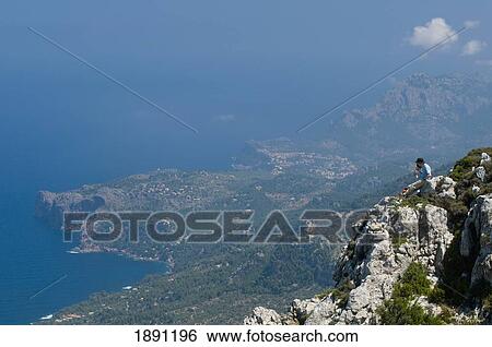 Two Hikers Sitting On Edge Of Mountain Looking At View, Side View View Large Photo Image Stock Photograph - Two Hikers Sitting On Edge Of Mountain Looking At View, Side View. Fotosearch