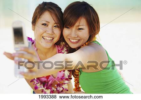 Two Japanese Girls Take A Picture Of Themselves With A Camera Phone View Large Photo Image Stock Photo - Two Japanese Girls Take A Picture Of Themselves With A Camera Phone. Fotosearch