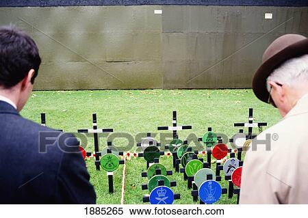 Stock Photography - Two Men At Grave Site On Remembrance Day. Fotosearch