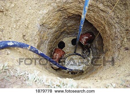 Stock Photo - Two Men Digging A Well. Fotosearch