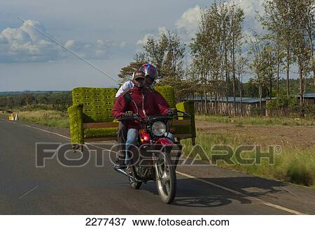 Two men on motorbike carrying sofa on back on road, near Nanyuki; Kenya View Large Photo Image Stock Photo - Two men on motorbike carrying sofa on back on road, near Nanyuki; Kenya. Fotosearch