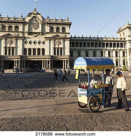 Stock Photo - Two Men Selling Beverages At A Cart In A Town Square; Guatemala City Guatemala. Fotosearch