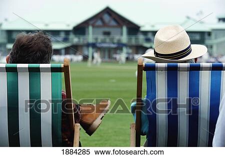 Stock Photography - Two Men Sitting In Striped Deckchairs. Fotosearch