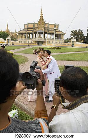 Two Men Taking Picture Newly Wed Couple In Front Of Royal Palace, Phnom Penh, Cambodia View Large Photo Image Stock Photo - Two Men Taking Picture Newly Wed Couple In Front Of Royal Palace, Phnom Penh, Cambodia. Fotosearch