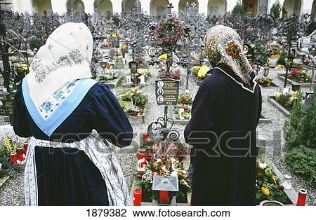 Stock Image - Two Old Woman In Scarves At Graveyard, Tyrol. Fotosearch