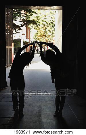 Stock Image - Two People Forming A Bridge With Their Hands; Beijing, China. Fotosearch