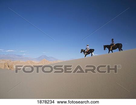 Picture - Two People Horse Riding In Valle De La Muerte. Fotosearch