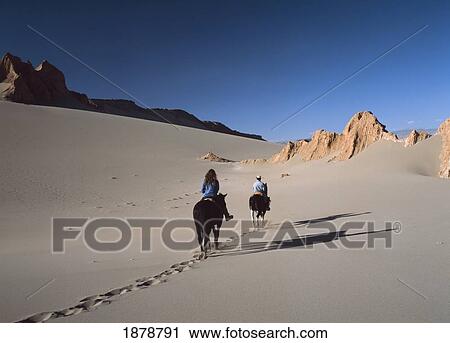Stock Image - Two People Horse Riding In Valle De La Muerte. Fotosearch