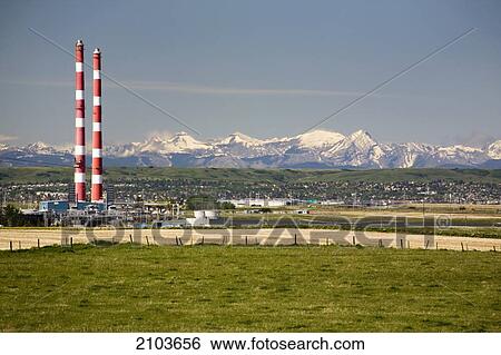 Two Red And White Stripped Smoke Stacks Of A Gas Plant With Snow Peaked Mountains In The Background And Blue Sky; Alberta Canada View Large Photo Image Stock Photograph - Two Red And White Stripped Smoke Stacks Of A Gas Plant With Snow Peaked Mountains In The Background And Blue Sky; Alberta Canada. Fotosearch
