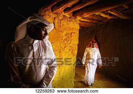 Stock Image - Two Saudis inside old fortress building; Taif, Saudi Arabia. Fotosearch