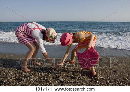 Two Sisters Collecting Shells On Beach View Large Photo Image Stock Image - Two Sisters Collecting Shells On Beach. Fotosearch