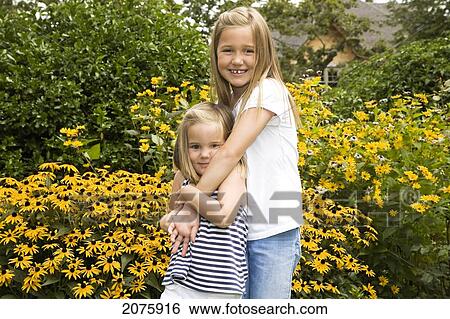 Two Sisters Hugging In A Summer Garden; Ontario Canada View Large Photo Image Stock Photograph - Two Sisters Hugging In A Summer Garden; Ontario Canada. Fotosearch