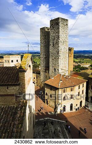 Two stone towers and pedestrians walking amongst the buildings; San Gimignano, Tuscany, Italy View Large Photo Image Stock Image - Two stone towers and pedestrians walking amongst the buildings; San Gimignano, Tuscany, Italy. Fotosearch