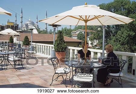 Stock Photo - Two Tourist Women At Rooftop Terrace. Fotosearch