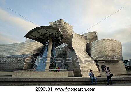Stock Image - Two Tourists In Front Of The Guggenheim Museum, Bilbao, Basque Country, Spain. Fotosearch