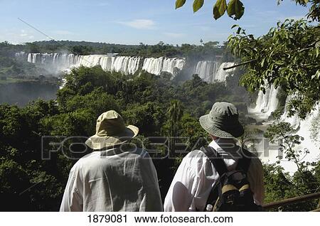 Stock Image - Two Tourists In Hats At Iguacu Falls. Fotosearch