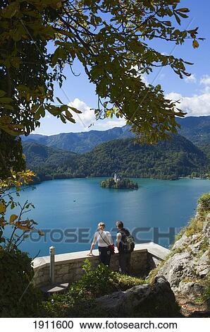 Stock Image - Two Tourists Looking At Lake Bled From Castle, Slovenia. Fotosearch