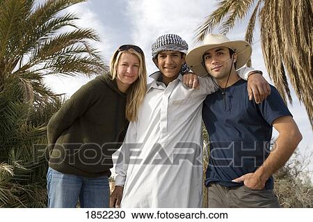 Two Tourists Posing With Young Egyptian Man View Large Photo Image Stock Image - Two Tourists Posing With Young Egyptian Man. Fotosearch