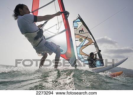Picture - Two windsurfers side by side in the water; tarifa cadiz andalusia spain. Fotosearch