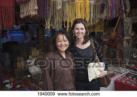 Stock Photo - Two Woman At A Market With Bhutanese Handicrafts; Thimphu Thimphu District Bhutan. Fotosearch