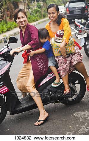 Stock Image - Two Women And Boy Sitting On Motorbike. Fotosearch