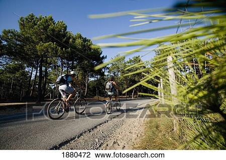 Stock Image - Two Women Cycling On Rural Road. Fotosearch