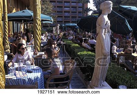 Stock Image - Two Women Eating Next To Statue, Marriott Hotel. Fotosearch
