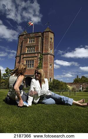 Stock Photograph - Two women enjoying the summer sun, Sissinghurst Castle, Kent, England, UK. Fotosearch