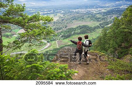 Picture - Two Women Hikers Overlooking The Cowichan Valley On Vancouver Island; British Columbia Canada. Fotosearch