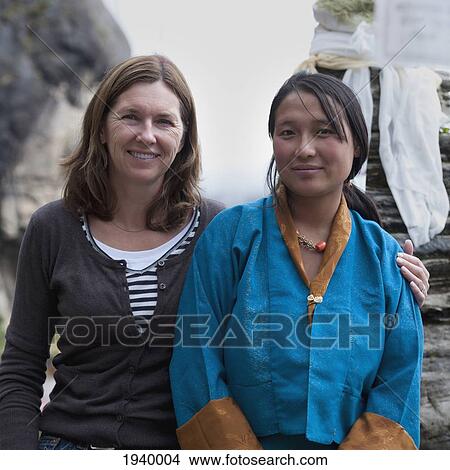 Picture - Two Women In An Embrace At Tiger's Nest Monastery; Paro District Bhutan. Fotosearch