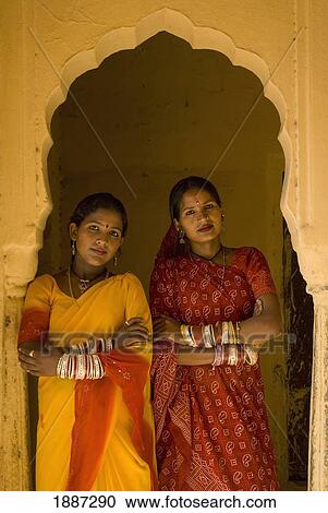 Stock Image - Two Women In Saris In Archway Of Old Building. Fotosearch