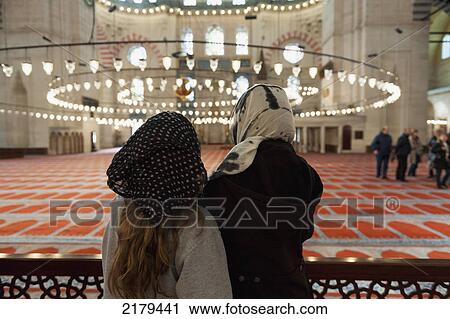 Stock Image - Two Women Looking At The Hanging Light Fixture In The Suleymaniye Mosque; Istanbul Turkey. Fotosearch