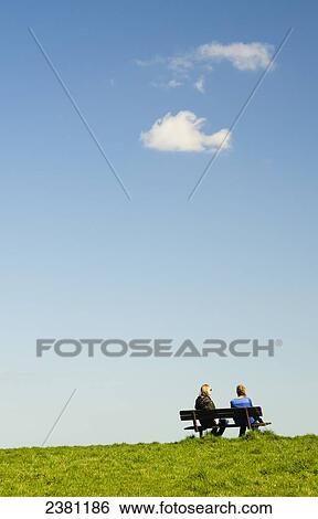 Stock Photograph - Two women sitting on a bench on Parliament Hill; Hampstead, England. Fotosearch