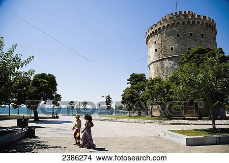 Picture - Two women walking past the White Tower; Thessaloniki, Greece. Fotosearch